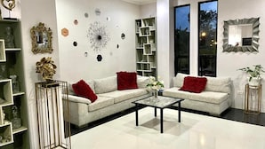 A modern living room with a sofa set, a coffee table, and decorative items on the walls. - Little Rock Cebu (Lapu-Lapu)