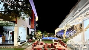 A courtyard with a swimming pool, outdoor seating, and a staircase leading to an upper level. - Little Rock Cebu (Lapu-Lapu)
