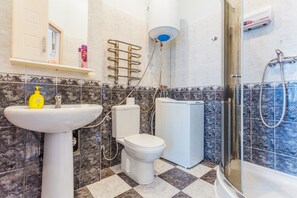 A bathroom with a sink, toilet, and shower. - Apartment Kreschatik Luteranskaya (Kyiv)