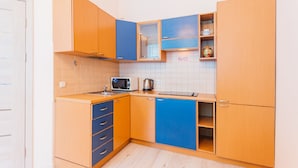 A compact kitchen with wooden cabinets, a microwave, and a kettle. - Apartment Kreschatik Luteranskaya (Kyiv)