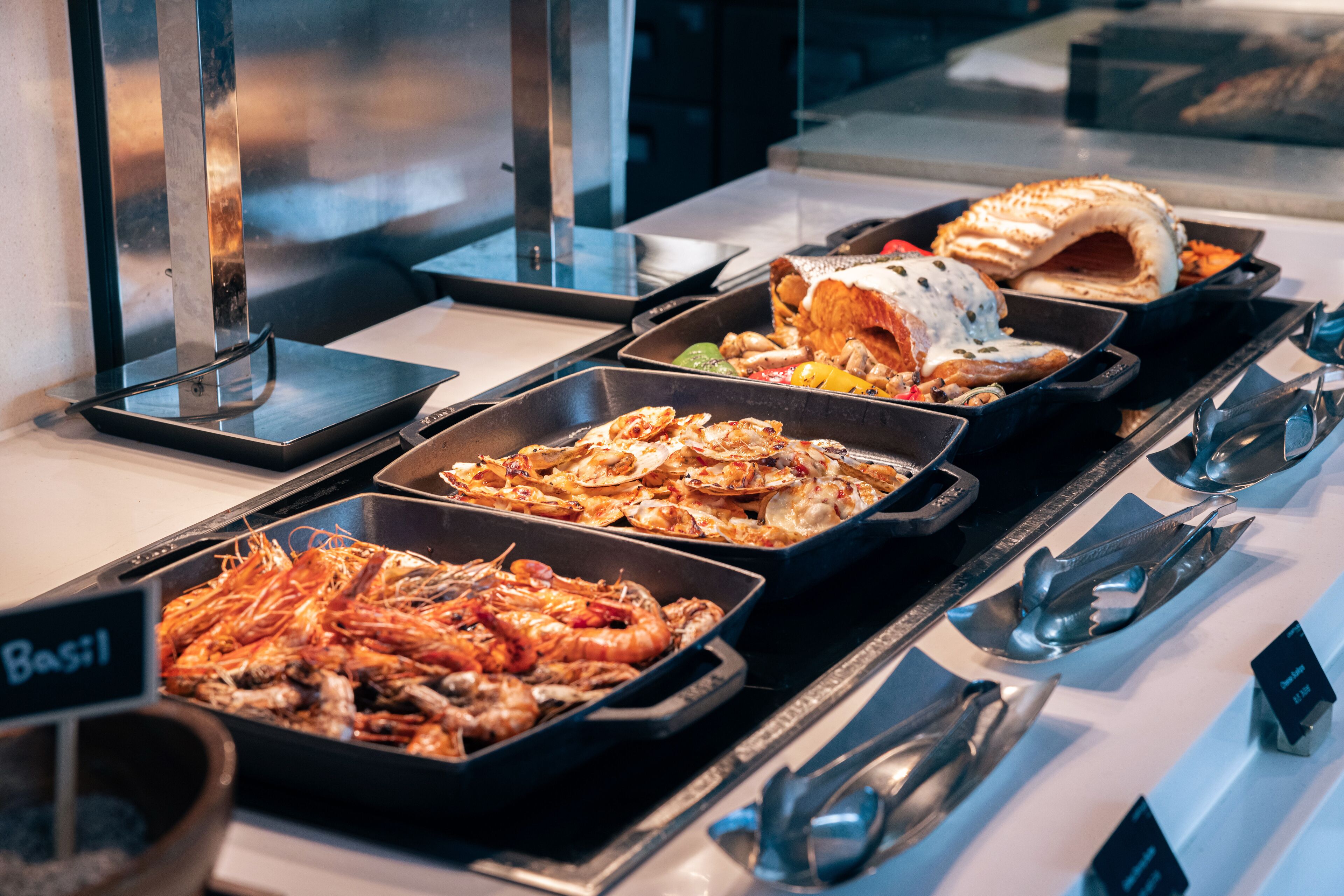 Un buffet proposant divers plats, notamment des crevettes et une pâtisserie.