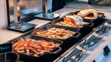 Un buffet proposant divers plats, notamment des crevettes et une pâtisserie.