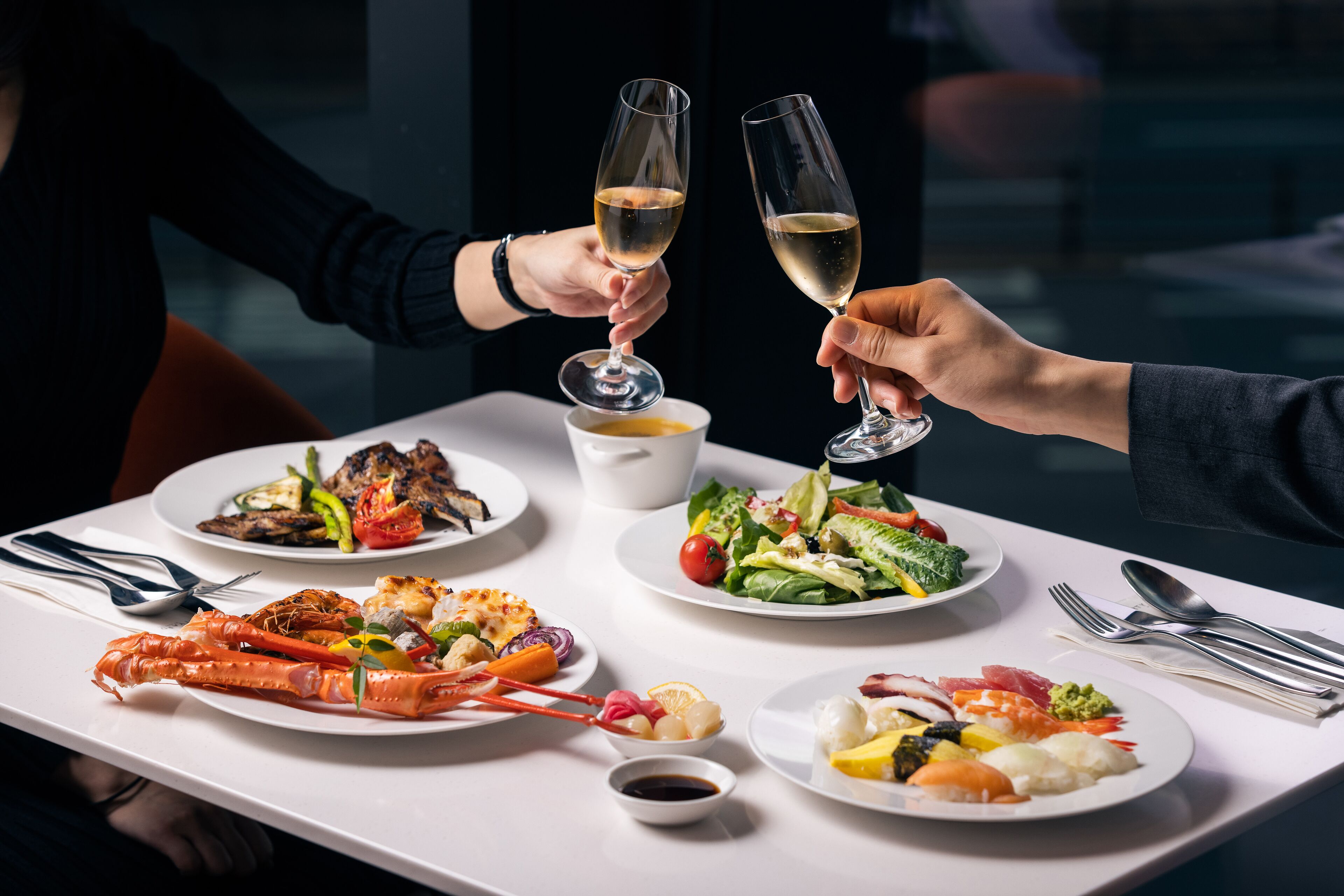 A dining table with various dishes including seafood, salads, and a lobster tail.