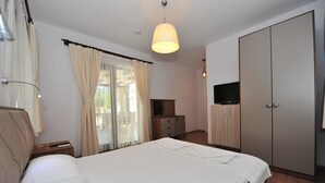 A hotel room with a bed, a TV, a wardrobe, and a desk with a lamp. - Egehan Butik Otel (Ortaca)