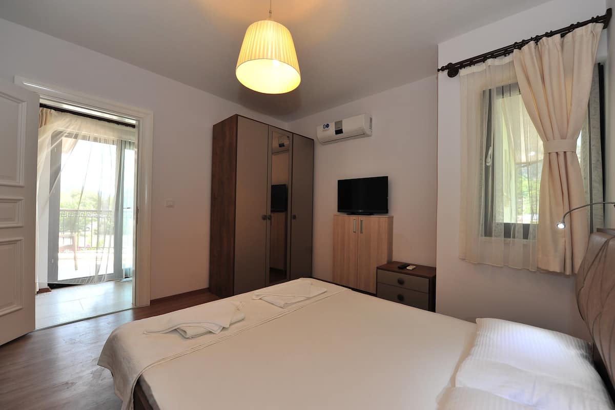 Un dormitorio con cama, armario, televisor y aire acondicionado.