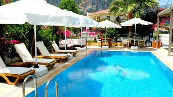 Piscine extérieure, parasols de plage, chaises longues