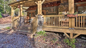 A rustic wooden cabin with a stone foundation, a wooden porch, and a sign that reads "Welcome." - Tubes & Outdoor Games: North Georgia Mtn Retreat (Sautee Nacoochee)