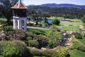 A golf course with a gazebo, lush greenery, and a lake. - Apartment in Pégomas with Private Pool (Pégomas)
