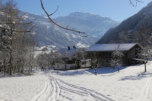 A snow-covered landscape with a wooden cabin and a mountain in the background. - Holiday Home in Aschau by Zillertal Alps (Aschau)