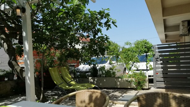 An outdoor seating area with wicker chairs and a table, surrounded by greenery and a white pergola. - LUCIJA 1 - Enjoy the Rovinj (Rovinj)