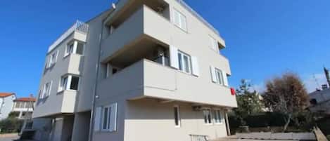 A multi-story building with balconies and a flat roof.