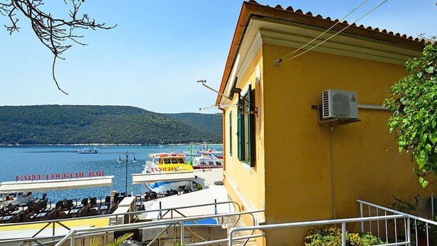 Un edificio giallo con un balcone che si affaccia su una marina piena di barche.