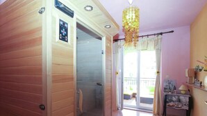 A room with a sliding glass door leading to a balcony, a small table with a lamp, and a decorative hanging light fixture. - Holiday house Vesna for relaxed vacation (Medulin)
