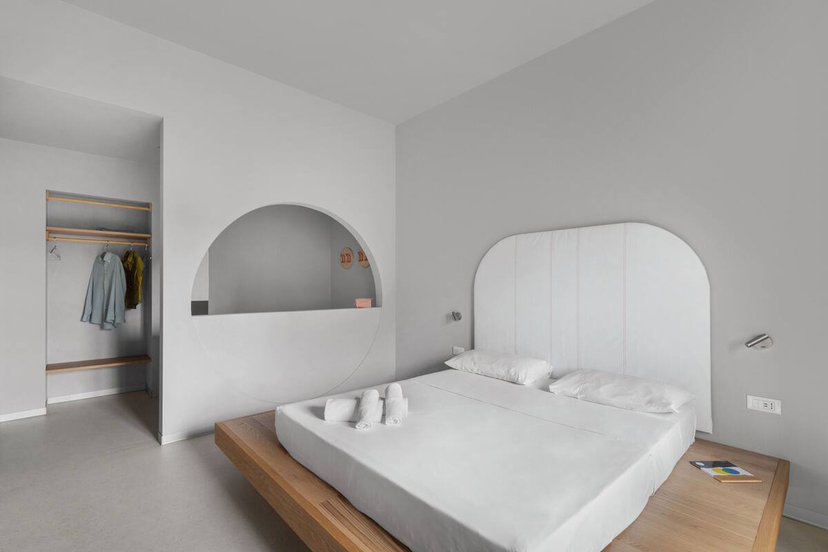 Une chambre à coucher moderne avec un lit, une armoire intégrée et un miroir.