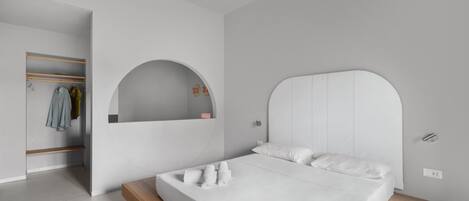 A modern bedroom with a bed, a built-in wardrobe, and a mirror.