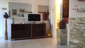 A living room with a television on a stand, a broom, and a vacuum cleaner. - Cozy apartment Nena in Medulin (Medulin)