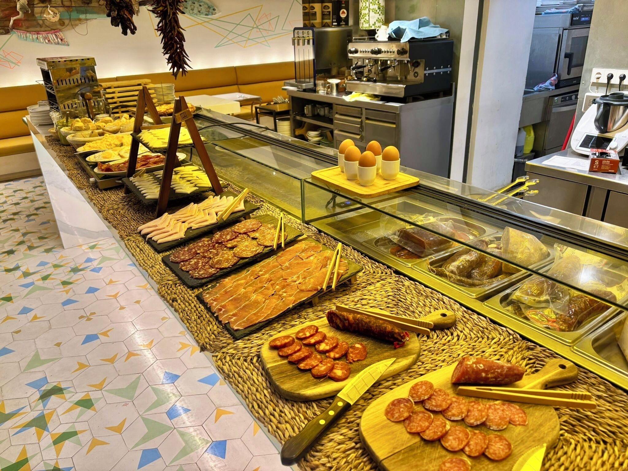 A buffet with various food items including meats, cheeses, and pastries.