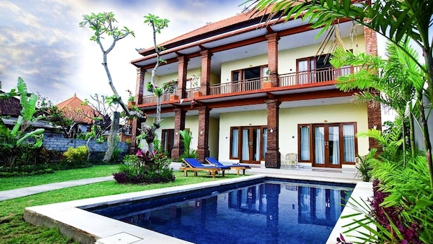 A two-story building with a swimming pool, a covered patio, and a garden. - Bali Billy Village (Canggu)
