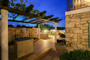 An outdoor patio area with stone walls, a pergola, and a pool. - Stunning Villa Bozini Dvori (Sveti Filip i Jakov)