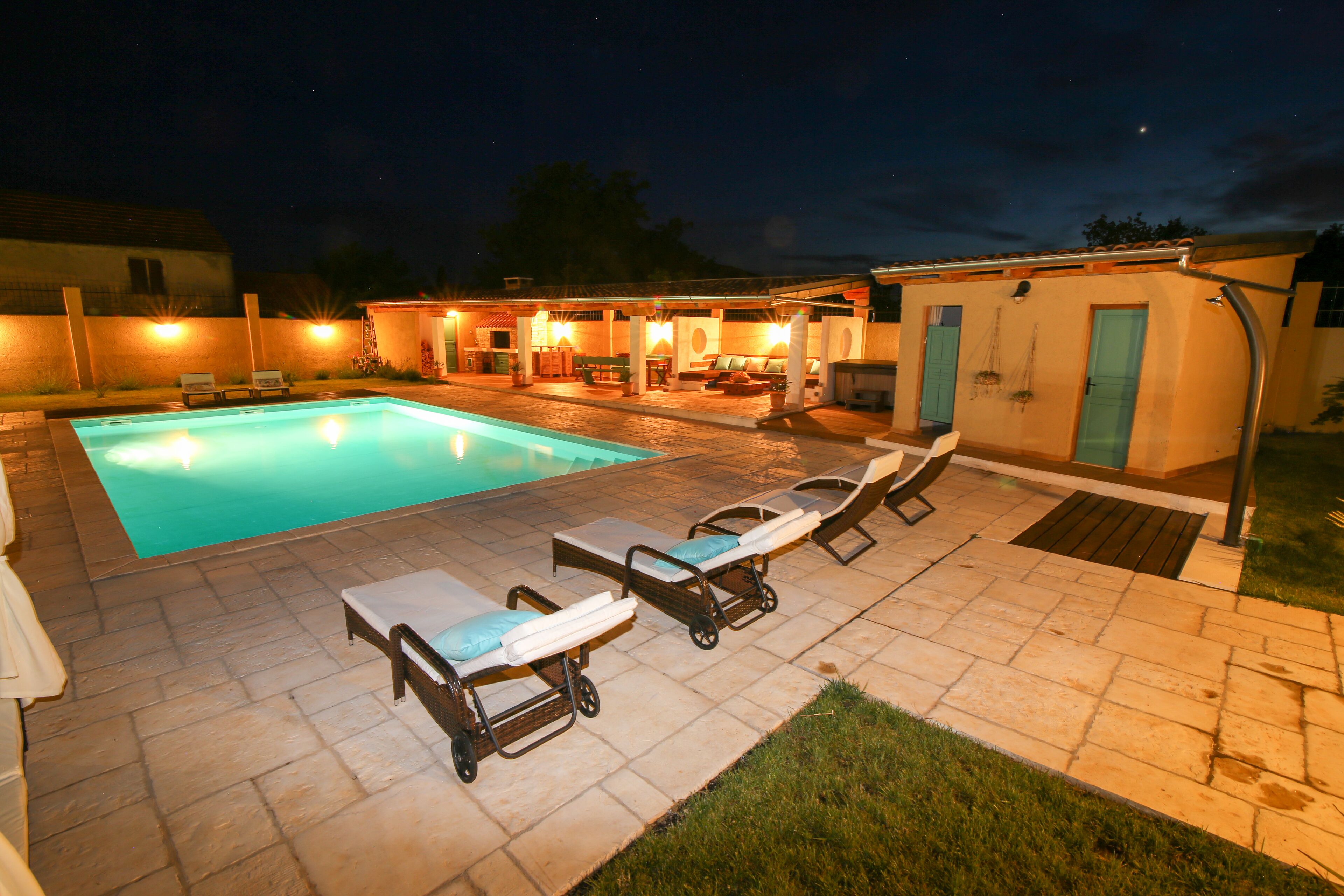 A swimming pool area with lounge chairs and a patio.