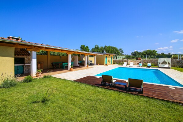Piscine extérieure en saison, chaises longues