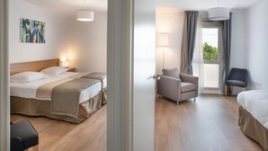 A hotel room with a bed, a chair, a desk, and a window with curtains. - DOMITYS - La Majolique (Béziers)