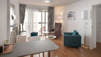 Una sala moderna con una mesa de comedor, un sofá, un sillón y una lámpara.
