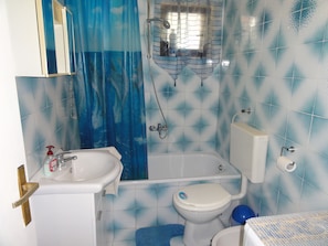 Un baño con bañera, inodoro y lavamanos.