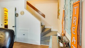 Eine Treppe mit Holzhandlauf und einer Wand mit dekorativen Schildern.