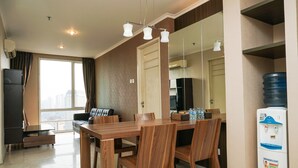 Un salon moderne avec une table à manger en bois, un canapé en cuir et une grande fenêtre agrémentée de rideaux.
