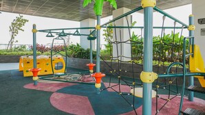 A playground with climbing structures and a slide. - Elegant Studio at Menteng Park Apartment (Jakarta)