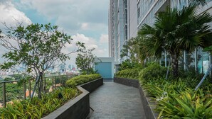 A pathway flanked by greenery and modern buildings, leading to a high-rise structure. - Elegant Studio at Menteng Park Apartment (Jakarta)