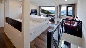 A modern hotel room with a large bed, a desk, a TV, and a balcony with a scenic view. - Windsor's Sunlight Han-Guan (New Taipei City)