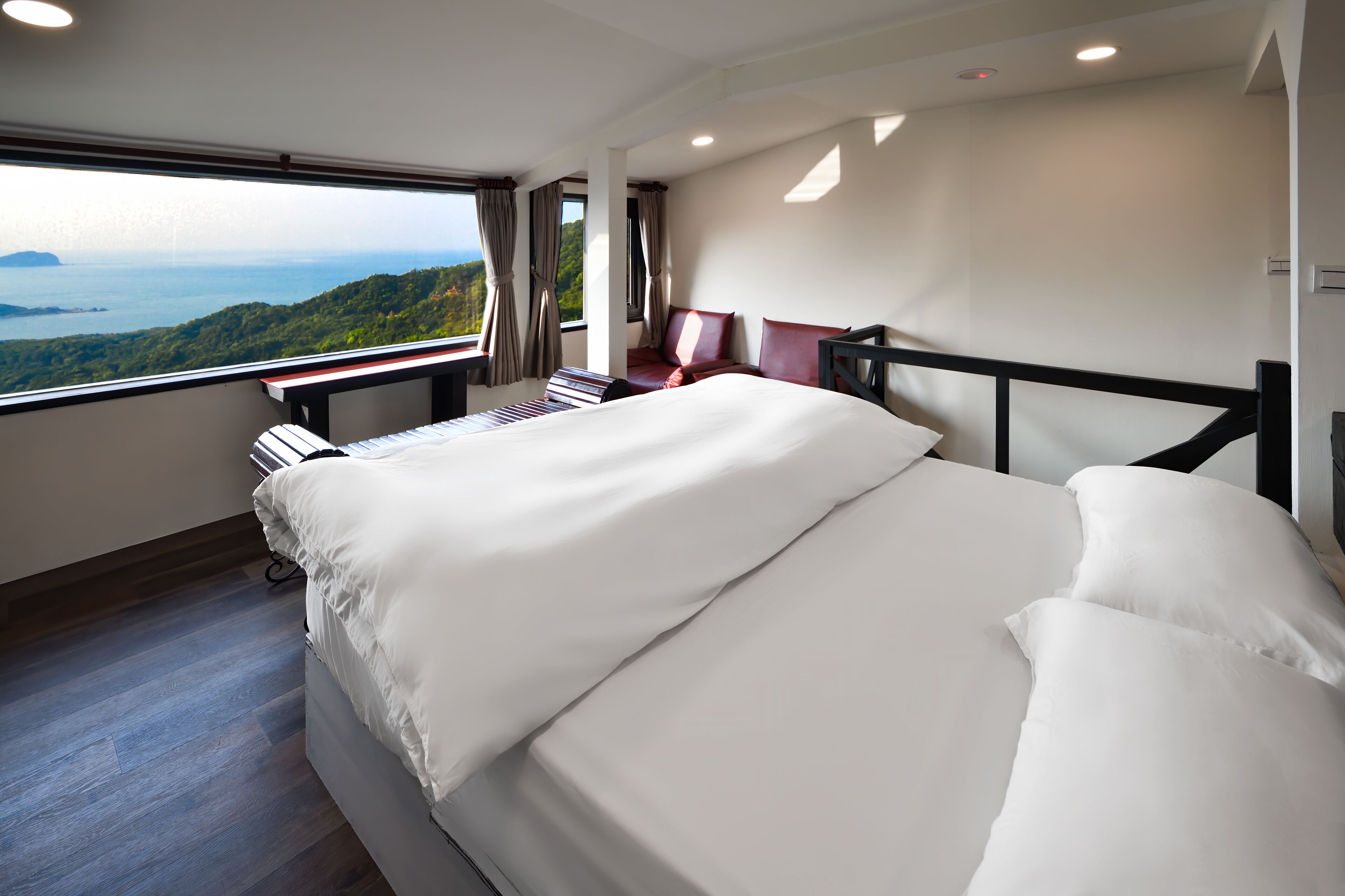 Une chambre dotée d’un grand lit, d’un bureau et offrant une vue sur un paysage montagneux.