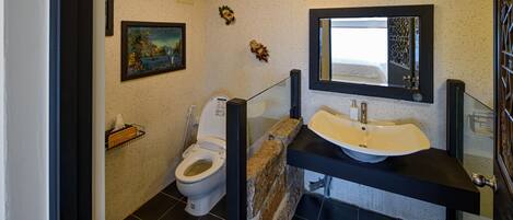 A bathroom with a toilet, sink, and mirror.