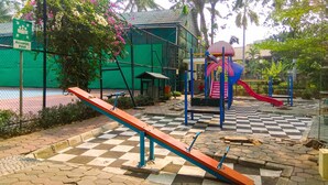 A playground with a seesaw, climbing structures, and a slide. - Comfy Studio at Menara Kondominium Kelapa Gading Apartment (Jakarta)