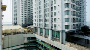 Un edificio de gran altura con varios balcones y una terraza en la azotea.