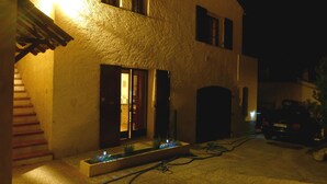 A building with a staircase, a door, and a car parked outside. - Les Pucines (Six-Fours-les-Plages)