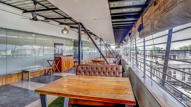 A modern interior with a high ceiling, exposed beams, and a view of the city through large windows. - Hotel Ajmer Regency (Ajmer)