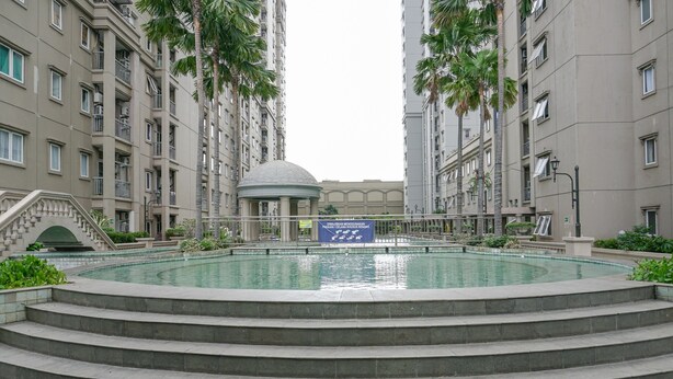 A swimming pool surrounded by a multi-story residential building with a dome structure in the center. - Brand New and Modern 3BR Grand Palace Kemayoran Apartment (Jakarta)