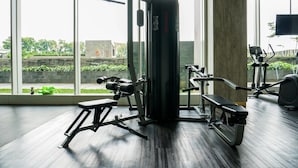 A gym with exercise equipment, large windows, and a view of greenery outside. - Highest Value 1BR Apartment at Ciputra International (Jakarta)