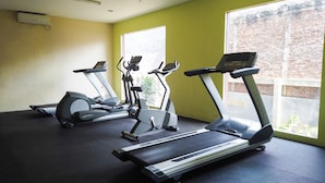 Une salle de sport équipée de tapis de course, d’elliptiques et d’un vélo d’appartement.
