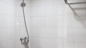 A shower with a chrome hose and wall-mounted controls.