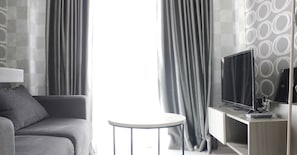 Relax in this stylish living area with a comfortable sofa, flat-screen TV, and geometric-patterned wall.