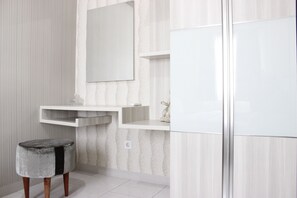 Bathroom features a white vanity, mirror, and glass shower enclosure.