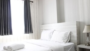 A neatly made bed with white linens and pillows, a bedside table with a lamp, and curtains on the window. - Modern 2BR Apartment at Mekarwangi Square Cibaduyut (Bandung)