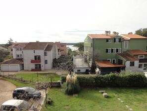 A residential area with multi-story houses, a paved driveway, and a grassy lawn. - Nice and Cozy Apartment Ferry in Medulin (Medulin)