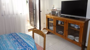 A room with a bed, a television on a wooden cabinet, and a door leading to an outdoor area. - Nice and Cozy Apartment Ferry in Medulin (Medulin)