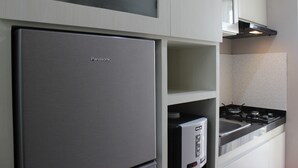 A kitchen with a stainless steel refrigerator, a microwave, and a gas stove.