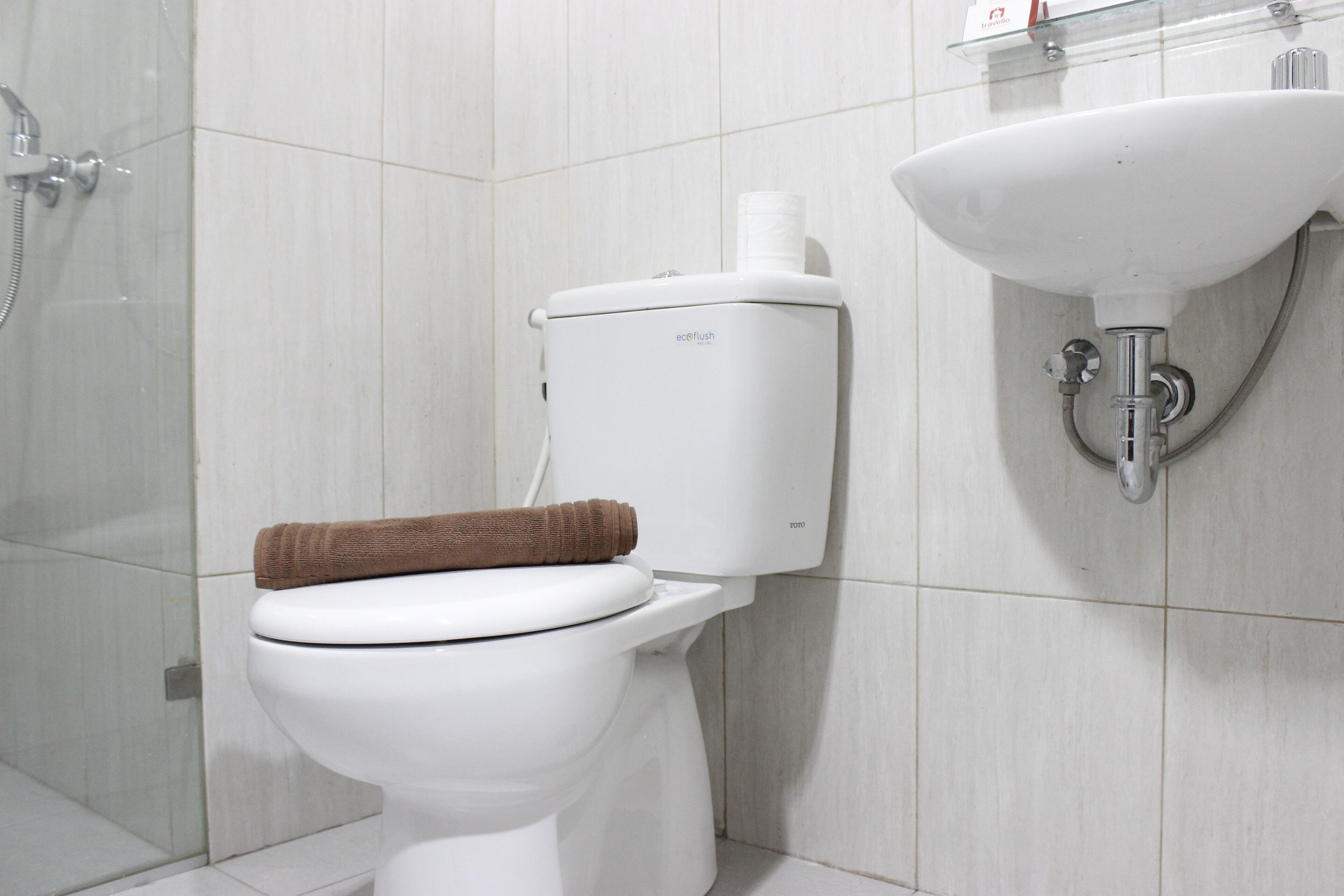 Ein modernes Badezimmer mit Toilette, einer Duschkabine aus Glas und einem wandmontierten Waschbecken.